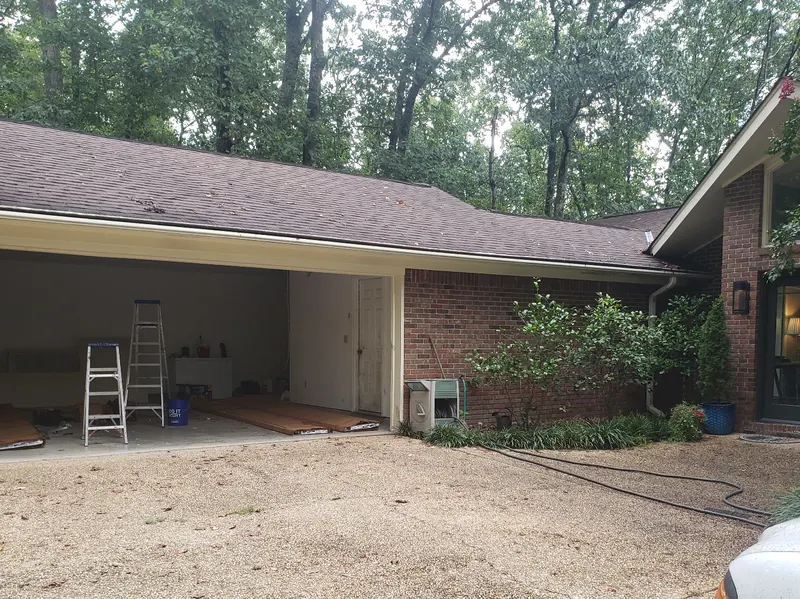 An open two-car garage with no door, a ladder inside
