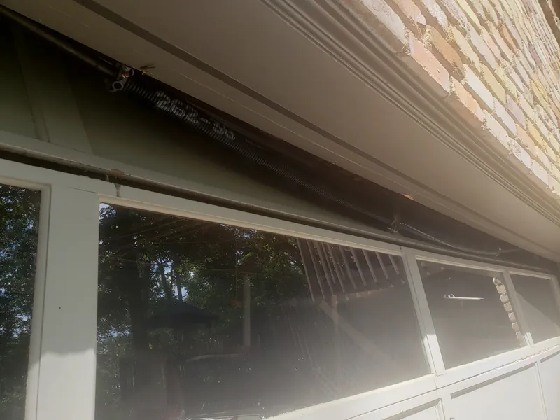 A worn garage door with damaged window panels, up close