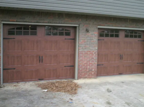 The same openings with new wood-grain carriage doors with arched windows