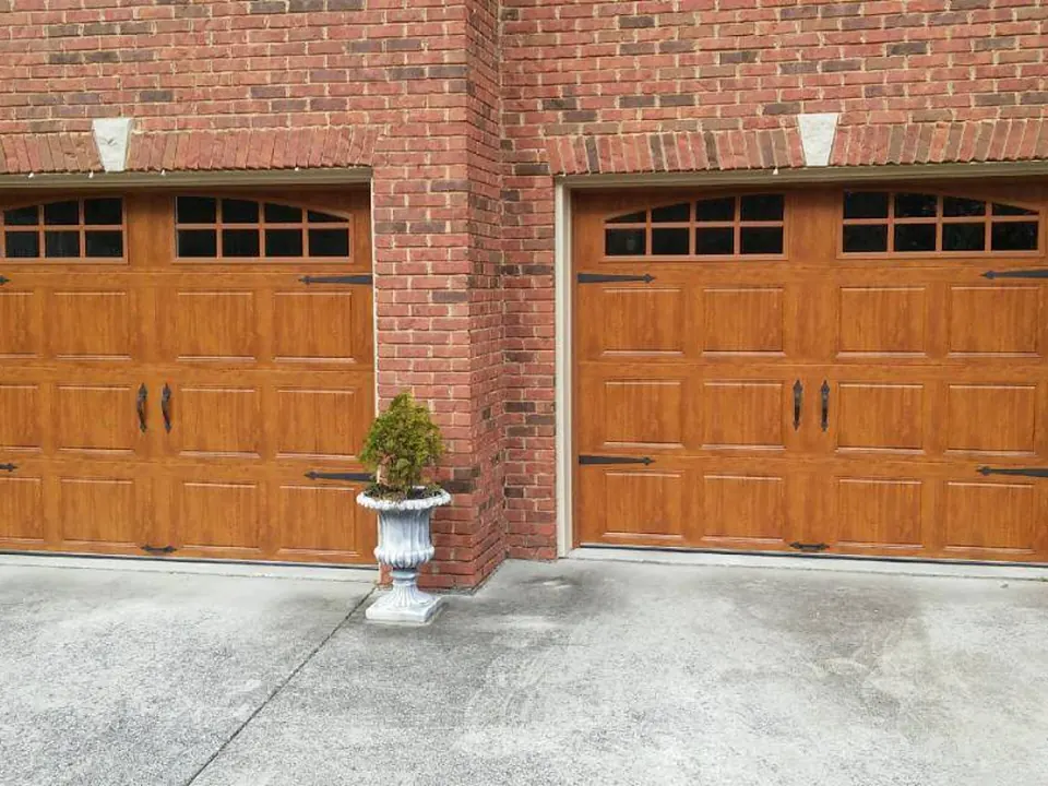 Wood-grain doors with arched windows: a Golden Garage Door Services job